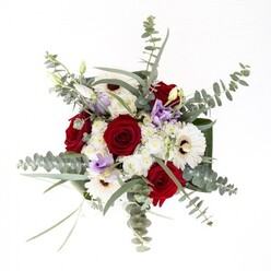 As curated by the expert hands at Creekmouth Flowers, this bouquet is a study in balance and textural contrast, as familiar and authentic as the local landscapes along the Thames. Plush, red roses form a romantic heart, their tightly ruffled petals capturing attention like hidden gems amidst the blooms. White gerbera daisies radiate from within, their snowy petals and espresso-toned eyes brightening the display, echoing the architecture of Creekmouth's historic lanes. Light purple lisianthus, with their soft, inviting buds, wander throughout, delivering a sense of gentle motion-much like the ebb and flow of the river nearby. Ivory clusters of delicate filler flowers nest among the main blossoms, infusing the bouquet with a cloud-like softness that brings to mind the airy openness of the riverbank's wild grasses. Eucalyptus, rich with silvery hues and aromatic promise, weaves through, arching into every corner and imbuing the ensemble with a fresh vibrancy. The entire piece is tightly framed at the base by broad, deep green leaves, their glossy sheen mirroring the robust health of flourishing local flora. Every stem, visible through the vase's clear water, attests to the arrangement's freshness-a standard cherished by Creekmouth's discerning customers. Whether for a birthday by the riverside, a welcome for a new neighbour, or an offering of sympathy, this floral masterpiece embodies the local artistry and heartfelt tradition of Creekmouth.